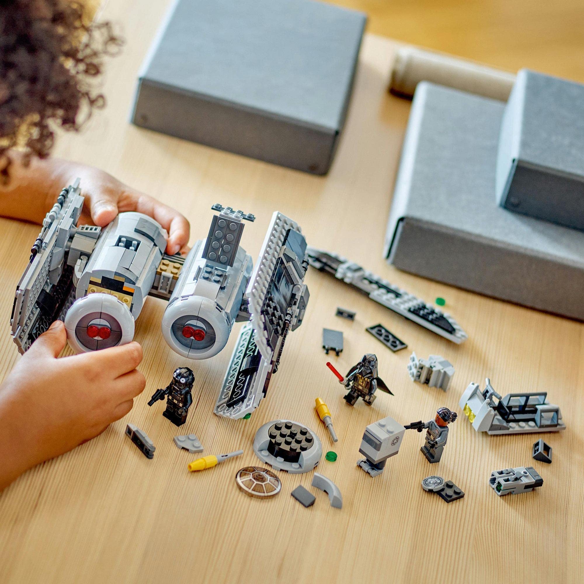 Child builds a colorful LEGO spaceship, surrounded by assorted bricks and imaginative figures.