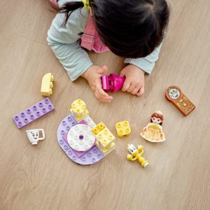Child playing with colorful blocks and figures, fostering imagination and creativity on a warm floor.