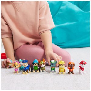 Childs hand engages with colorful toy figures, sparking imaginative play and storytelling.