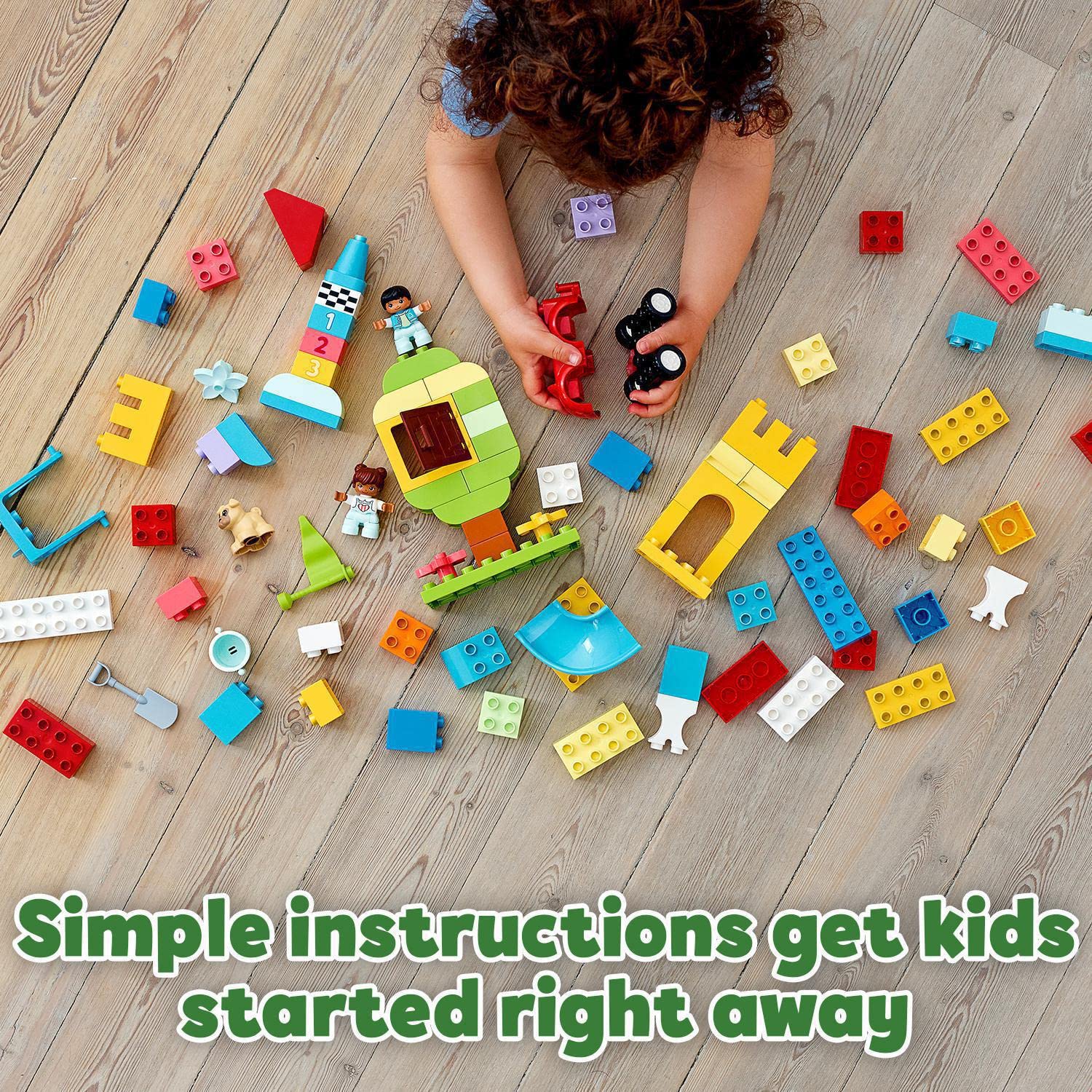 Child joyfully builds with colorful blocks on a wooden floor, fostering creativity and learning.