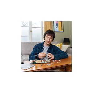 Man focused on electronics project in cozy living room with natural light and warm decor.