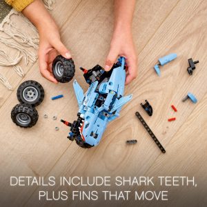 Creative assembly of a shark-inspired vehicle model on a warm wooden floor.