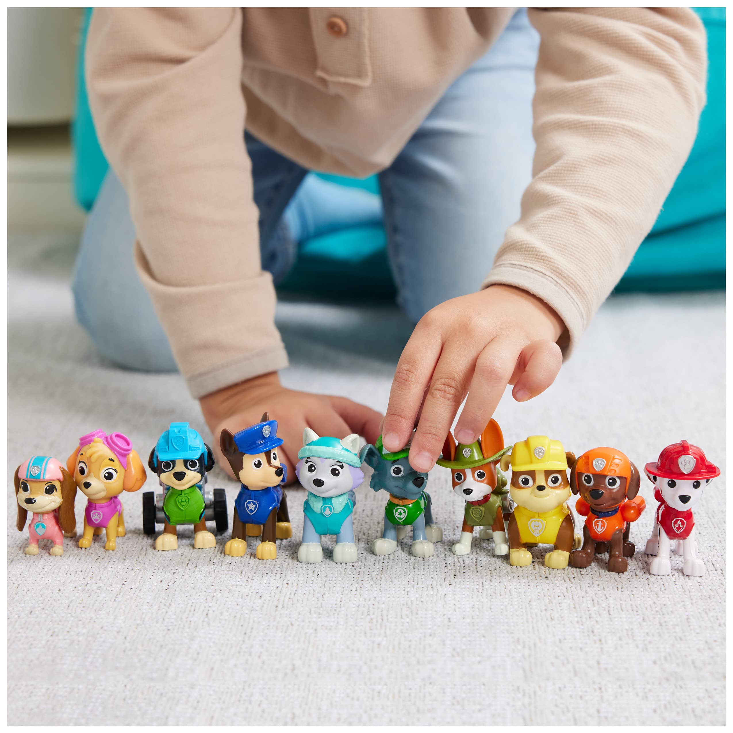 Colorful toy dogs in vibrant outfits inspire imaginative play in a cozy indoor setting.
