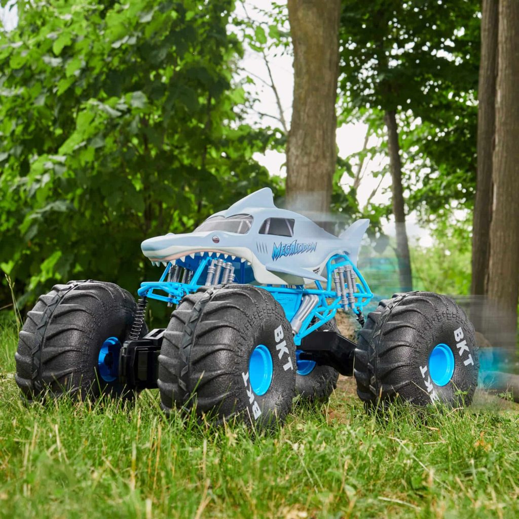 Shark-themed remote-controlled monster truck racing through a lush landscape, embodying outdoor adventure and fun.