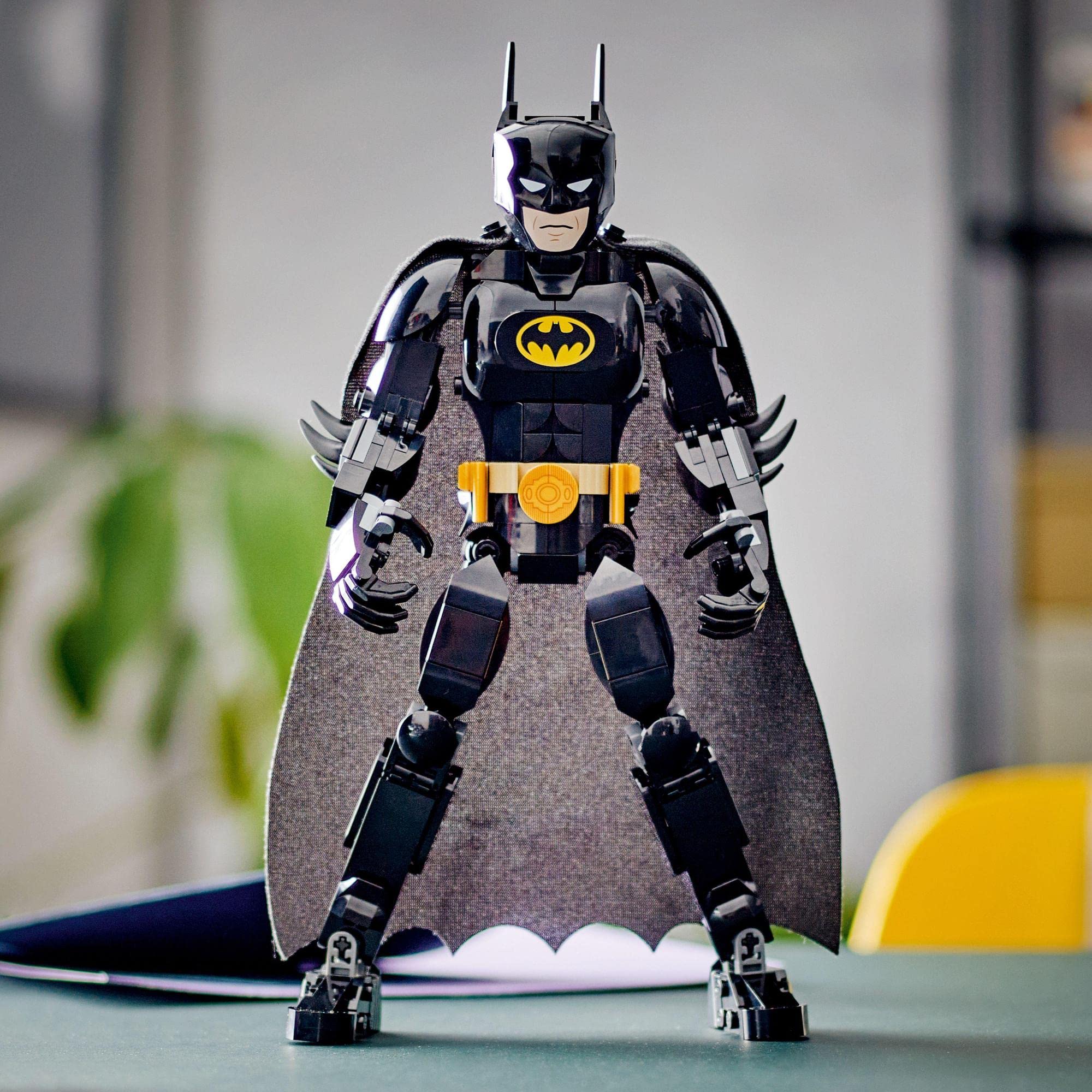 Dynamic Batman action figure with flowing cape, detailed suit, and striking yellow utility belt.