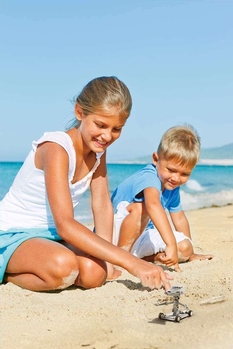 Joyful beach day: children play in sand, building creations and sharing laughter by the ocean.