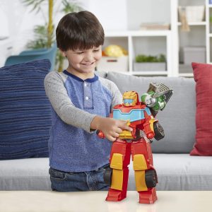 Young boy joyfully interacts with a colorful toy robot in a cozy living room.