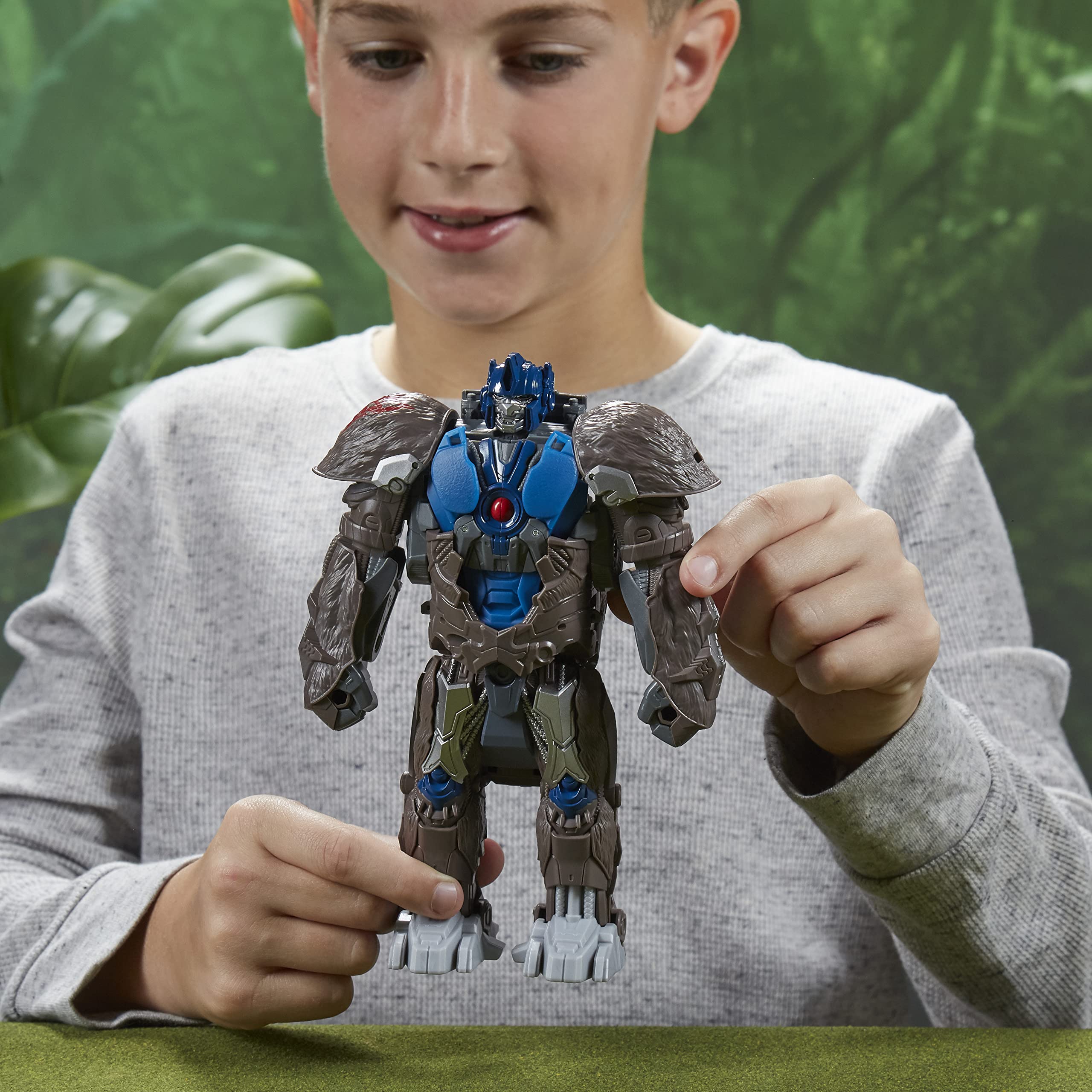 Joyful boy enjoying imaginative play with a vibrant robot action figure in nature.