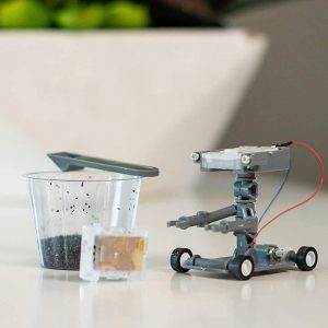 Intricate robotic gardening assistant next to soil cup, blending technology with nature in a workspace.