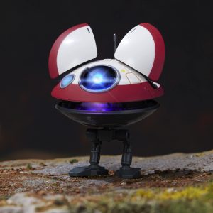 Playful red and white robot with a glowing blue eye, standing in a natural setting.