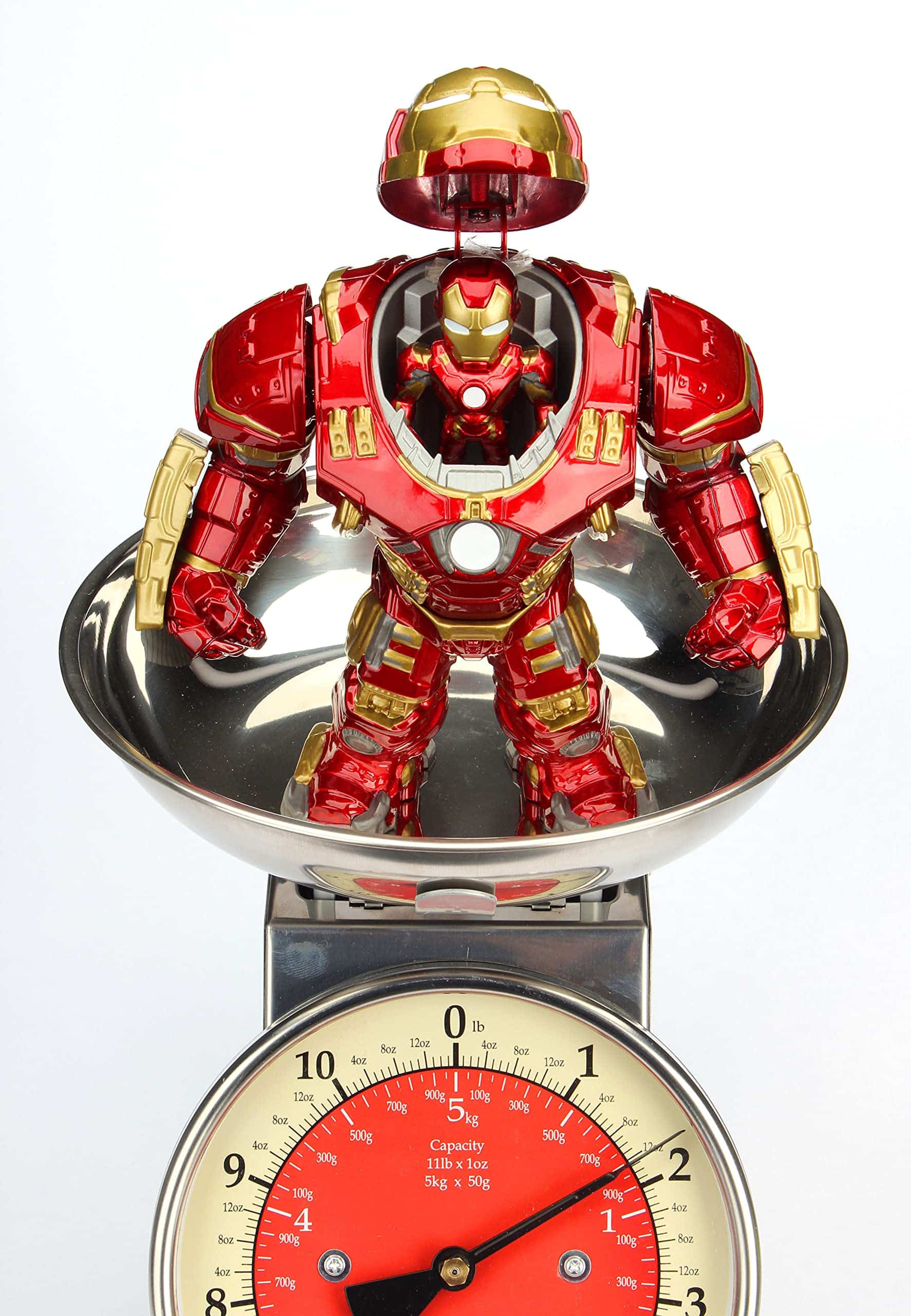 Superhero action figure in vibrant armor balances playfully on a classic kitchen scale.