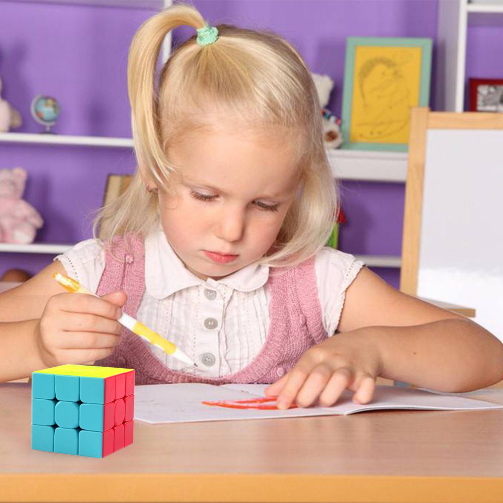 Young girl drawing intently, colorful Rubiks Cube nearby in a cozy creative space.