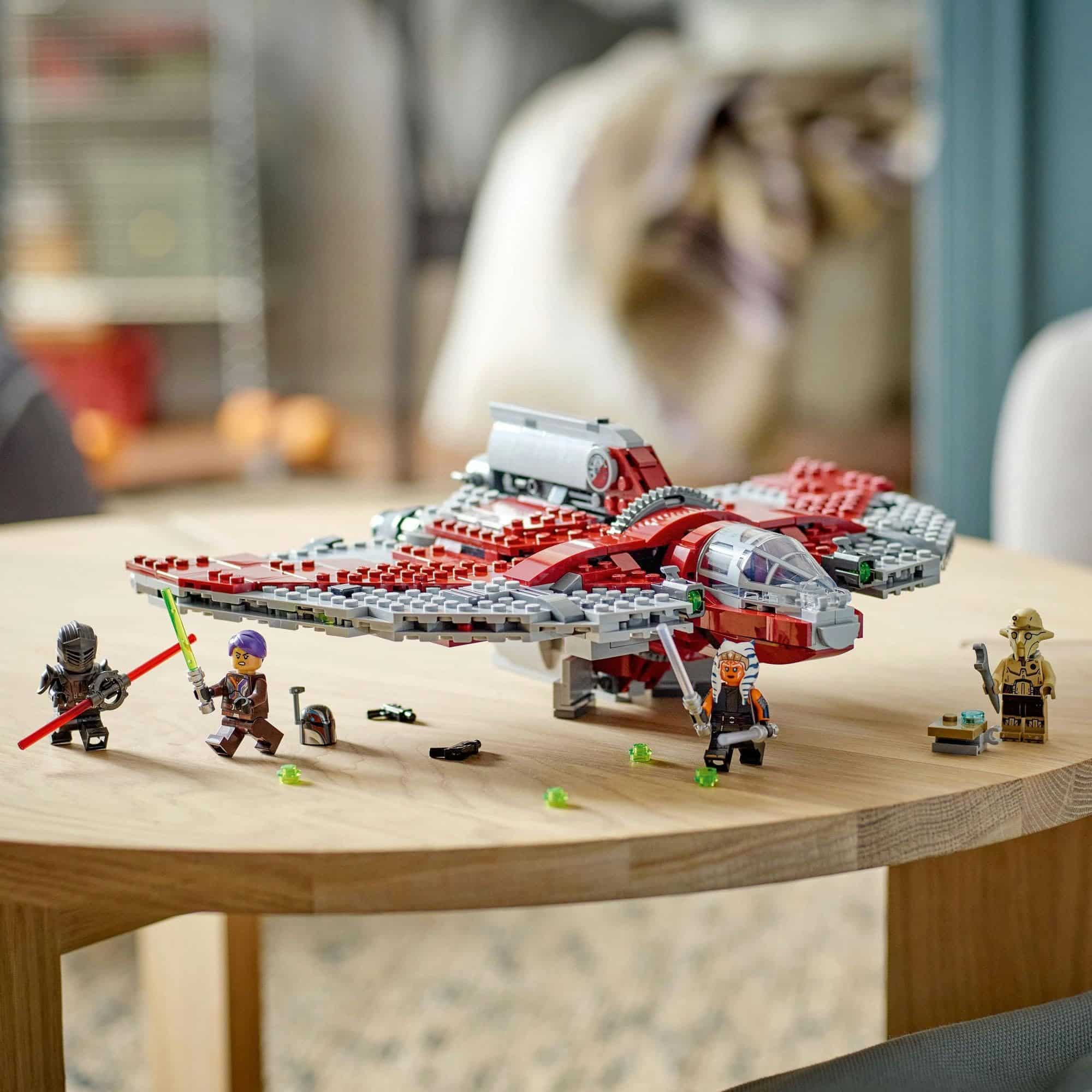 LEGO starship adventure scene with minifigures, lightsaber, and imaginative accessories on a wooden table.
