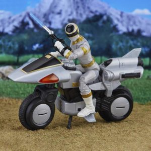 Action figure in dynamic pose on modern motorcycle, set against a vibrant mountain landscape.