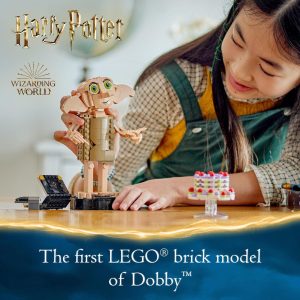 Young girl builds a LEGO® Dobby model, embracing creativity in a cozy play space.
