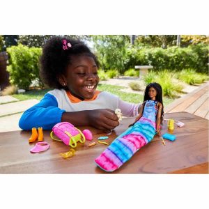 Cheerful girl enjoys imaginative play with a colorful doll in a sunny garden setting.
