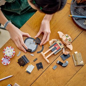 Young builder creating a colorful LEGO fantasy character on a sunny craft table.
