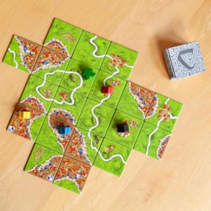 Engaging board game with colorful tiles and player pieces on a rustic wooden tabletop.