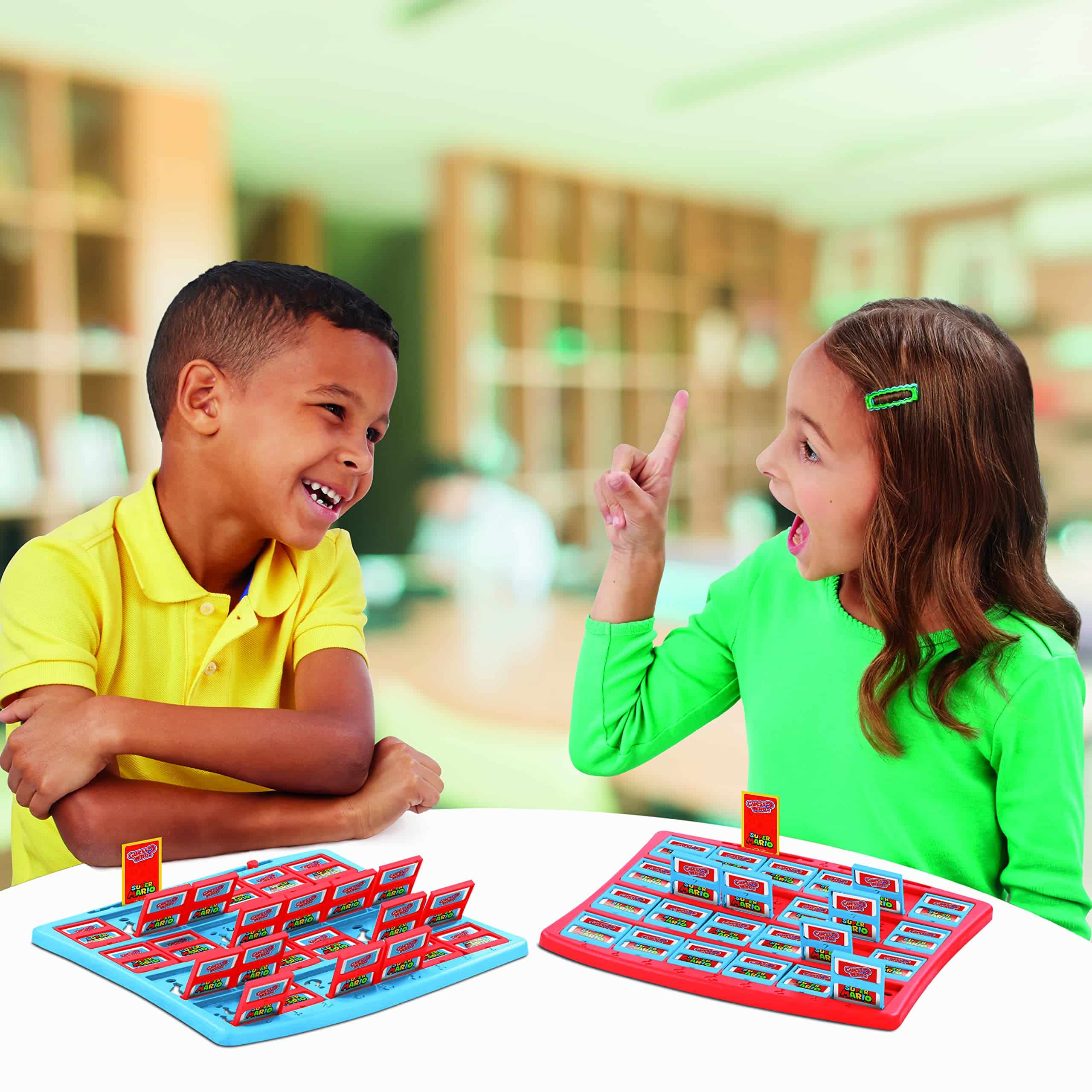 Children happily playing Guess Who? in a vibrant indoor setting, showcasing friendly competition.