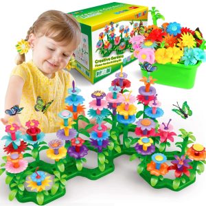Young girl in yellow dress explores creativity with colorful flower-building playset in imaginative garden.