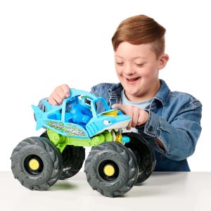 Young boy joyfully plays with a colorful monster truck toy, sparking imagination and fun.