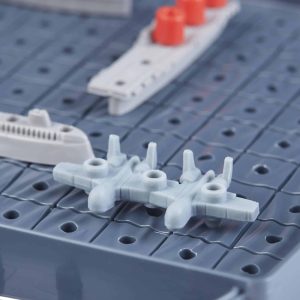 Miniature naval scene featuring an aircraft and vessels on a textured gray dock.
