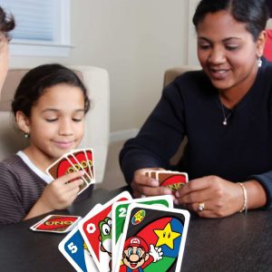 Family bonding over a colorful card game in a cozy indoor setting.