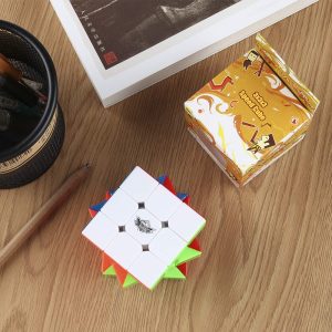 Vibrant workspace featuring a Rubiks Cube, puzzle box, book, and writing tools on wood.