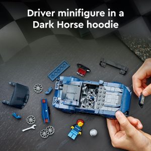 Minifigure builder works on a blue car in a vibrant racing themed scene.