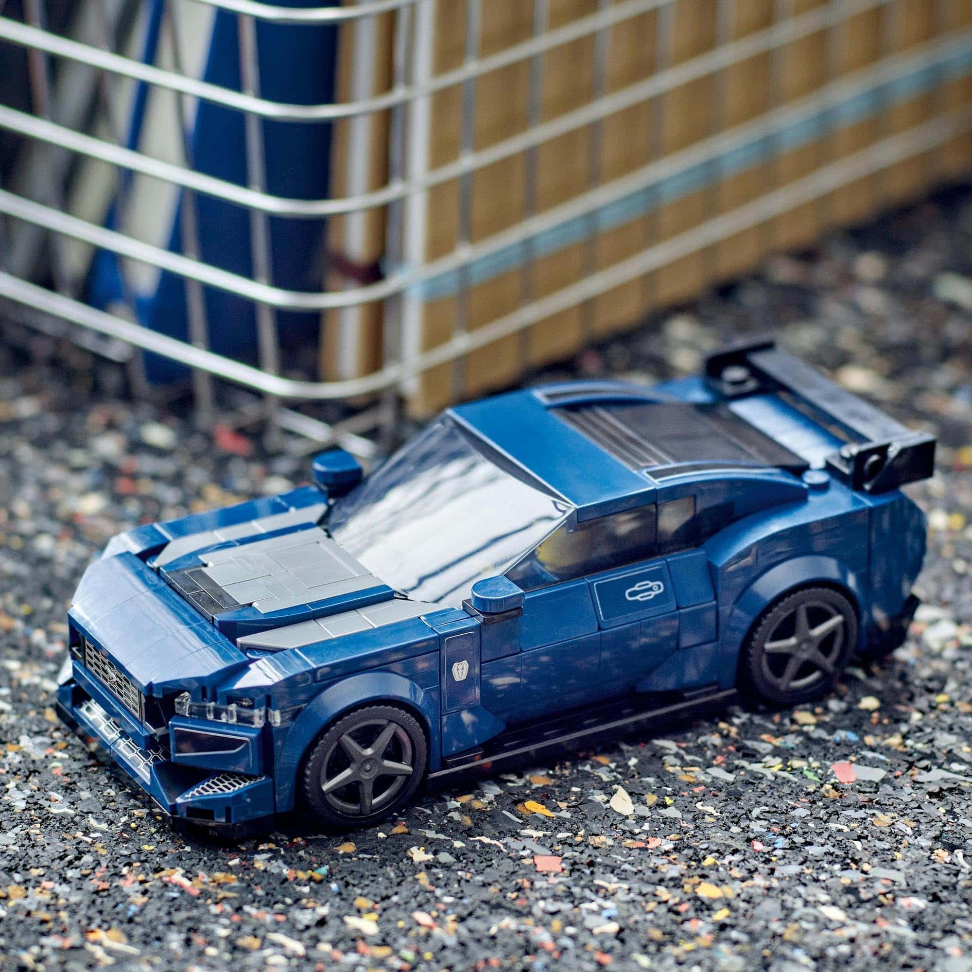 Sleek blue sports car model on asphalt, showcasing high-performance design and craftsmanship.