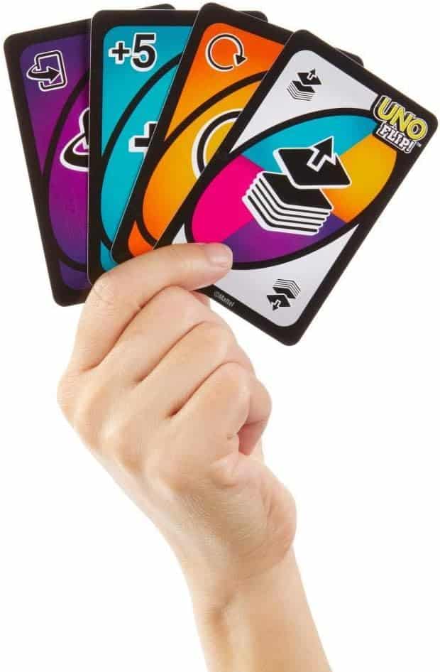 Hand holding four vibrant action cards from an exciting strategic card game.