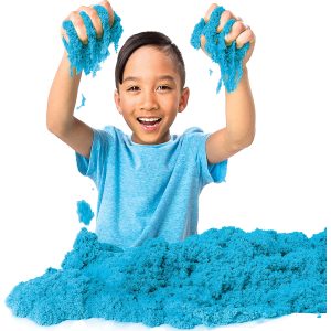 Joyful boy exploring fluffy blue sensory material, embodying creativity and carefree playfulness.