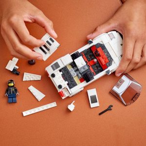 Engaging LEGO vehicle assembly with scattered pieces and a mechanic figurine on a warm table.