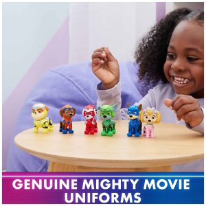 Young girl joyfully plays with colorful Mighty Movie toy figures at a wooden table.
