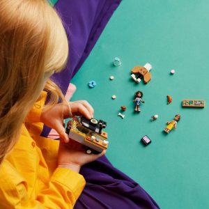 Child playing with colorful toys, exploring imagination and creativity against a teal background.