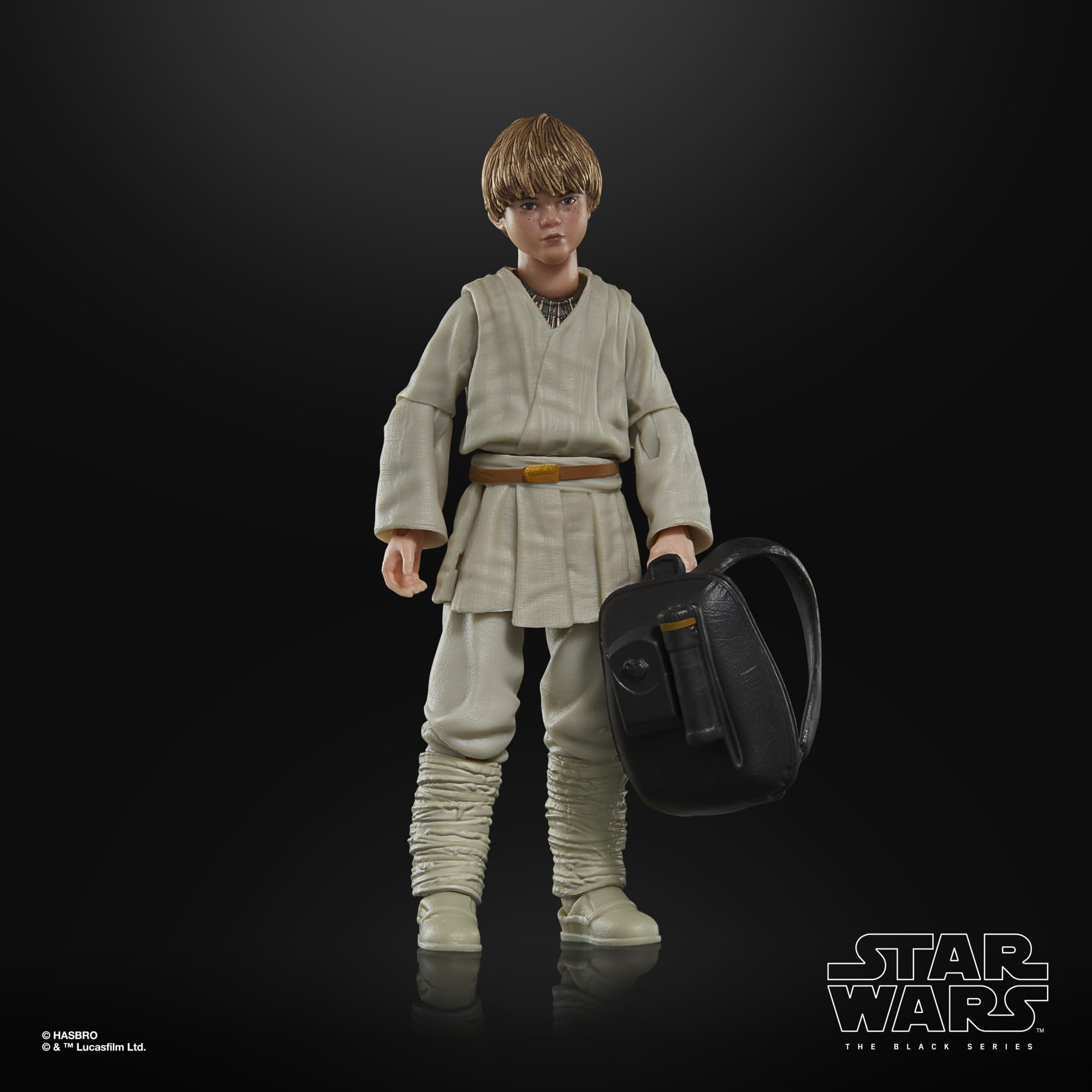 Collectible young Star Wars action figure in robes, with detailed features and a black bag.