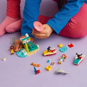 Young girl immersed in creative play with colorful LEGO water toys against a cheerful backdrop.