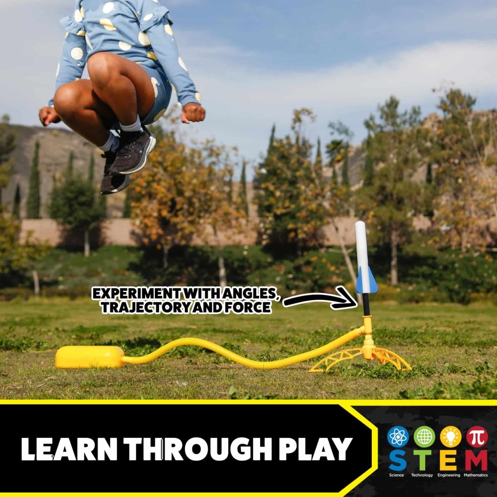 Child joyfully jumps near a yellow STEM toy, blending outdoor play with hands-on learning.