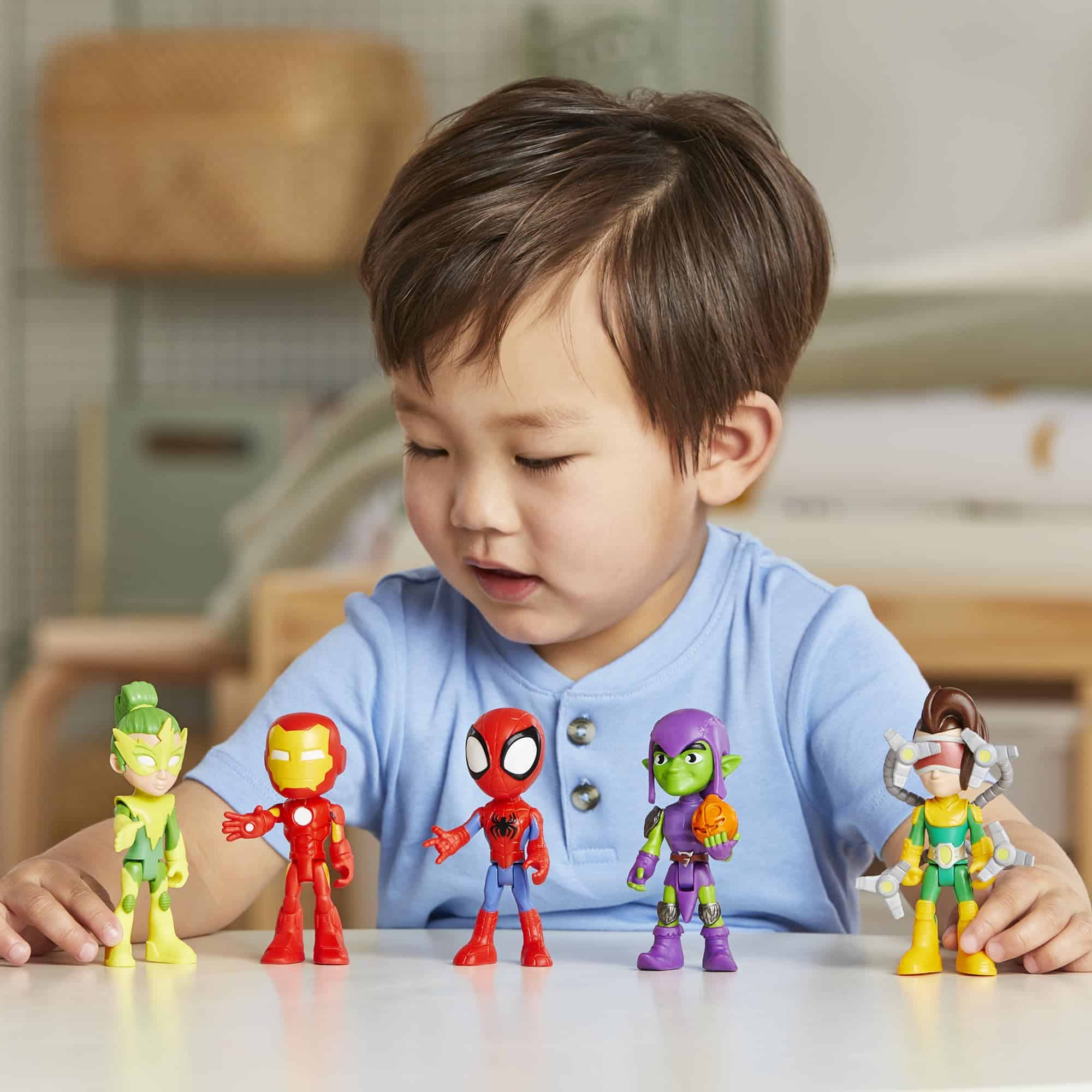 Boy happily explores colorful action figures, sparking his imaginative playtime adventures.