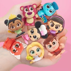 Vibrant character figures evoke joy and nostalgia, held playfully against a soft pink background.