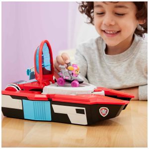 Joyful boy playing with a colorful rescue boat toy in a bright, cheerful setting.