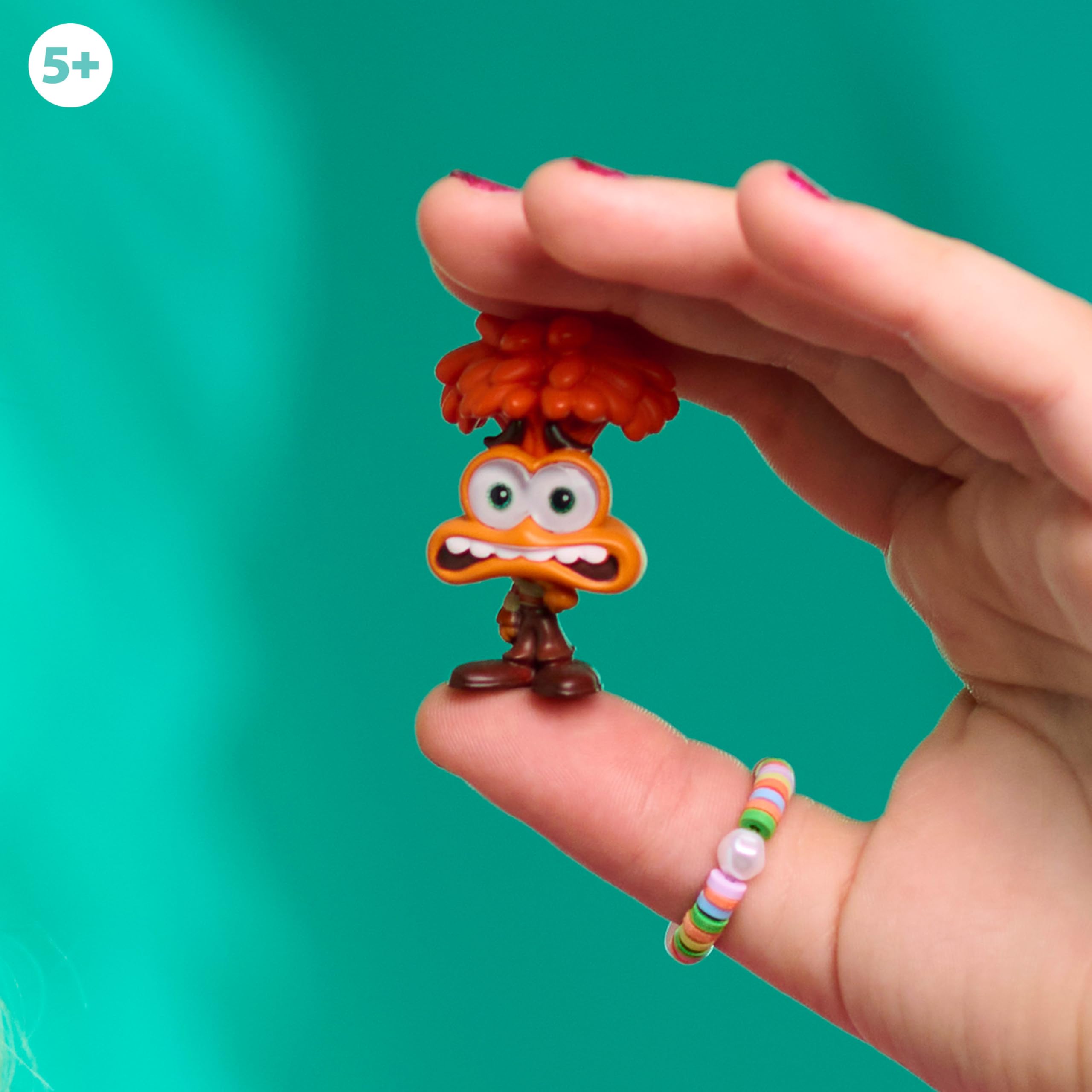 Vibrant toy figure sparks creativity in a childs hand against a bright teal background.