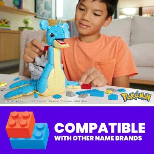 Young boy joyfully builds a colorful Pokémon figure with vibrant blocks in a cozy home.