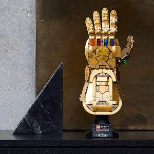 Beautiful LEGO Golden Gauntlet collectible with colorful stones against a bronze backdrop, a nostalgic tribute.