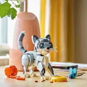 Charming LEGO gray and white cat with colorful mouse in a cozy playroom setting.