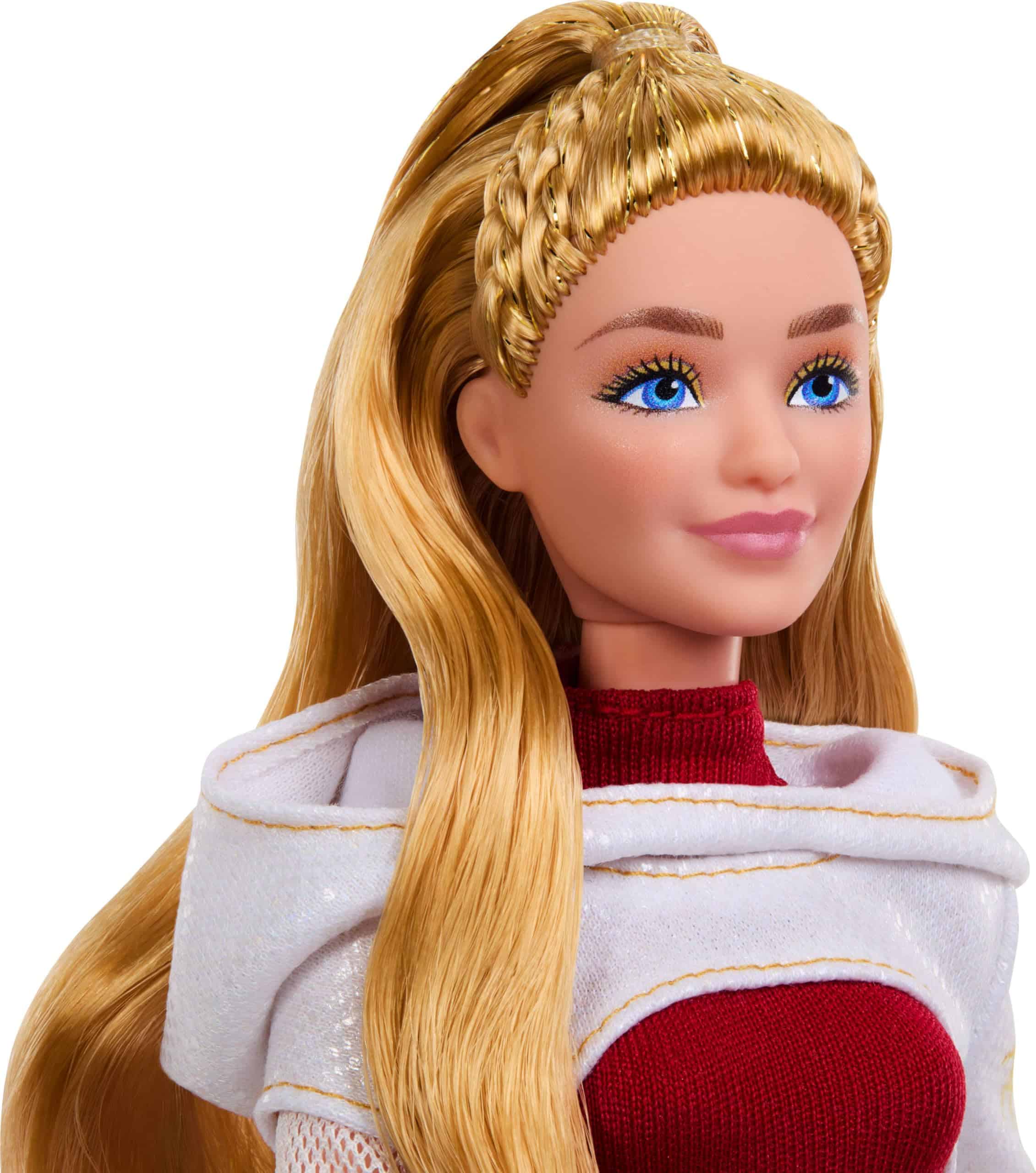 Elegant fashion doll with blue eyes, blonde waves, burgundy top, and white cape.