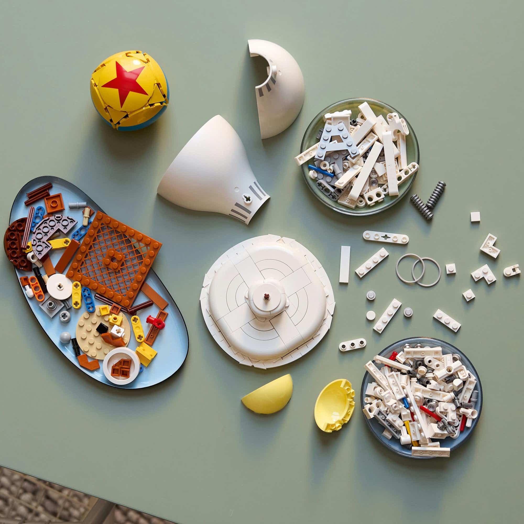 Colorful LEGO collection sparks creativity on a minimalist green surface with playful elements.