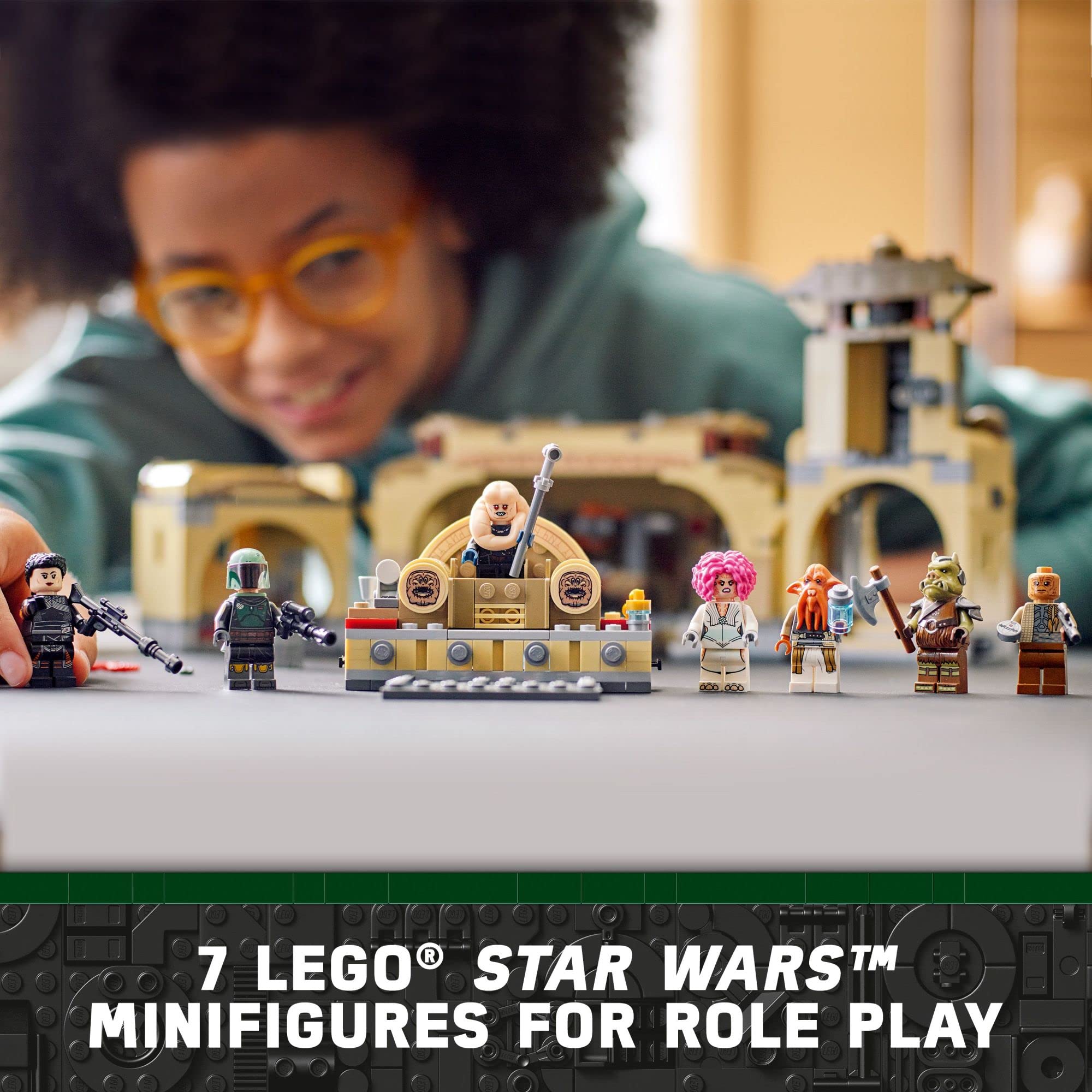 Child plays with colorful LEGO Star Wars minifigures in a detailed themed playset.