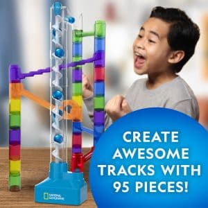 Joyful boy explores colorful marble run toy, creating tracks and enhancing STEM learning with 95 pieces.