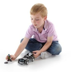 Young boy playing with superhero car toy, showcasing creativity and imaginative storytelling.